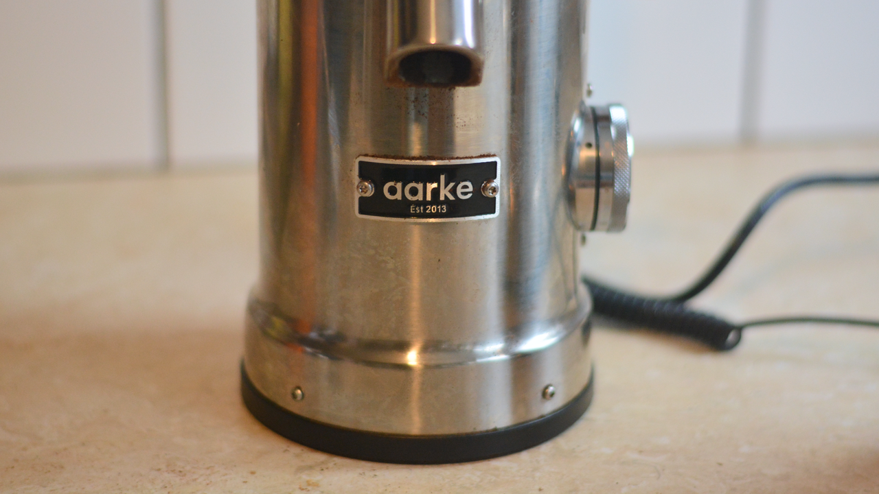 Image of the Aarke Coffee System &ndash; a stainless steel coffee bean grinder and drip coffee maker &ndash; positioned on a kitchen counter