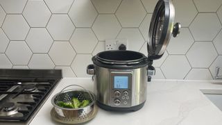 Breville the Fast Slow Pro on a kitchen countertop with brocolli