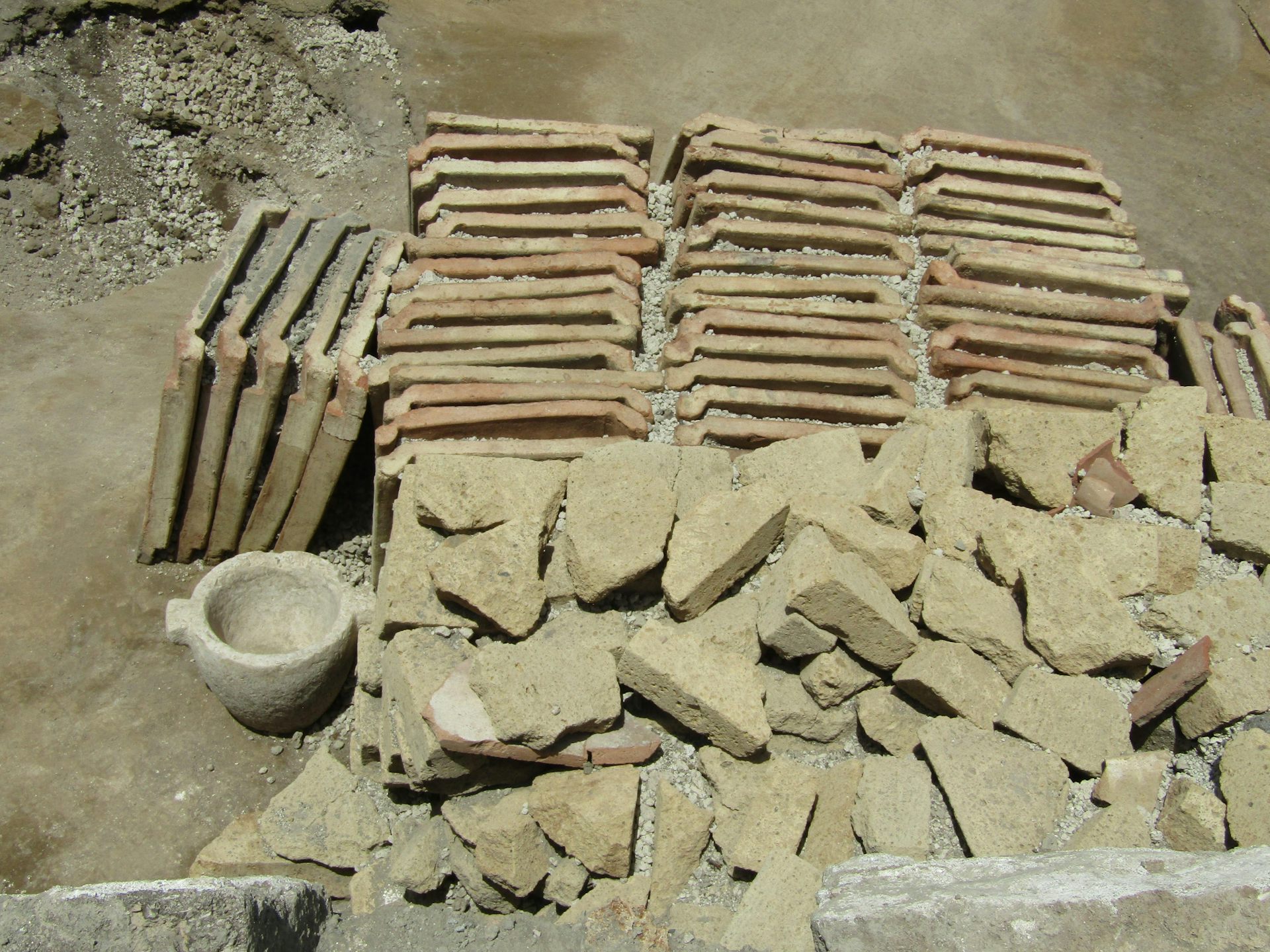 Neatly aligned ceramic roof tiles and tuff blocks at a newly excavated site in Pompeii.