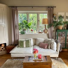 country-style living room with white sofa and yellow chair and lots of cushions