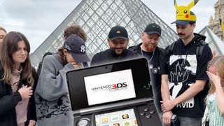 A Nintendo 3DS handheld game console and a group of people looking sad as they hold a funeral for the console in front of the Louvre pyramid