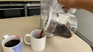 Pouring hot coffee into a mug