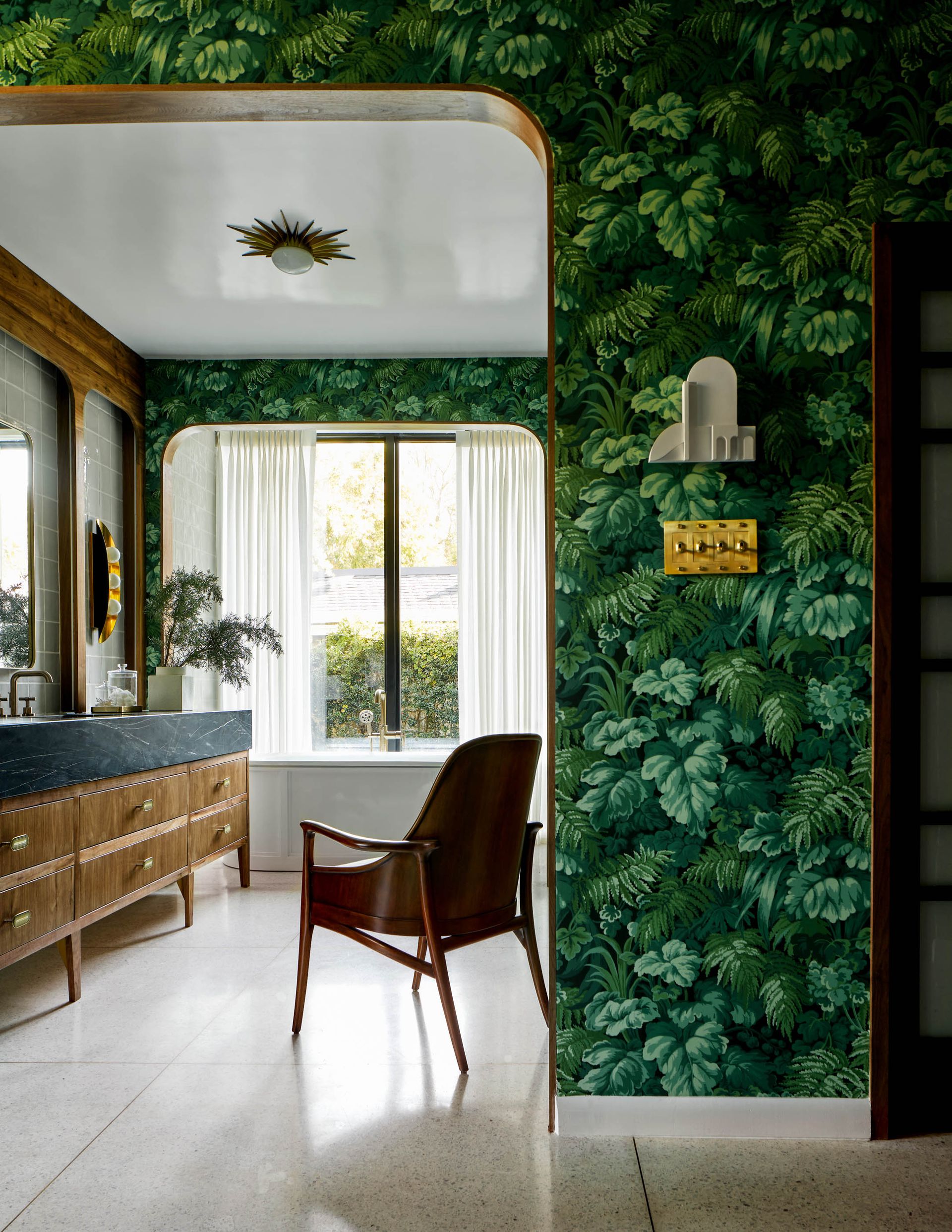 A bathroom with wallpaper and a white curtain by the bathtub