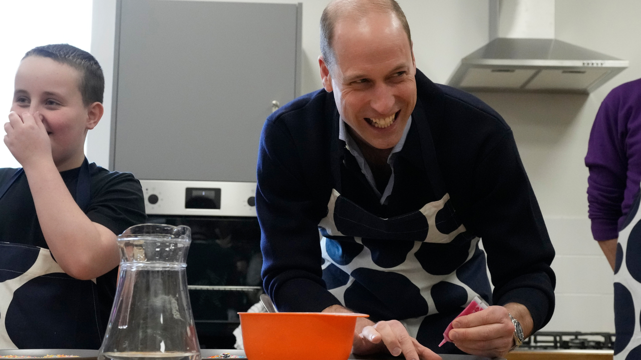 Prince William, Prince Of Wales smiles as he looks up while decorating biscuits during his visit to WEST, a new OnSide Youth Zone WEST on March 14, 2024 in London, England.