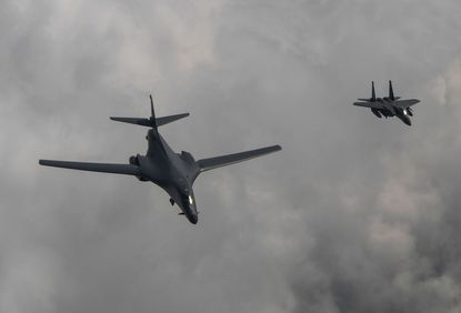 U.S. Air Force B-1B Lancer bomber (L) fly with South Korean fighter jet F-15K fighter jet over the Korean Peninsula