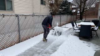 Tester using Pro Paddle Attachment to remove snow from patio