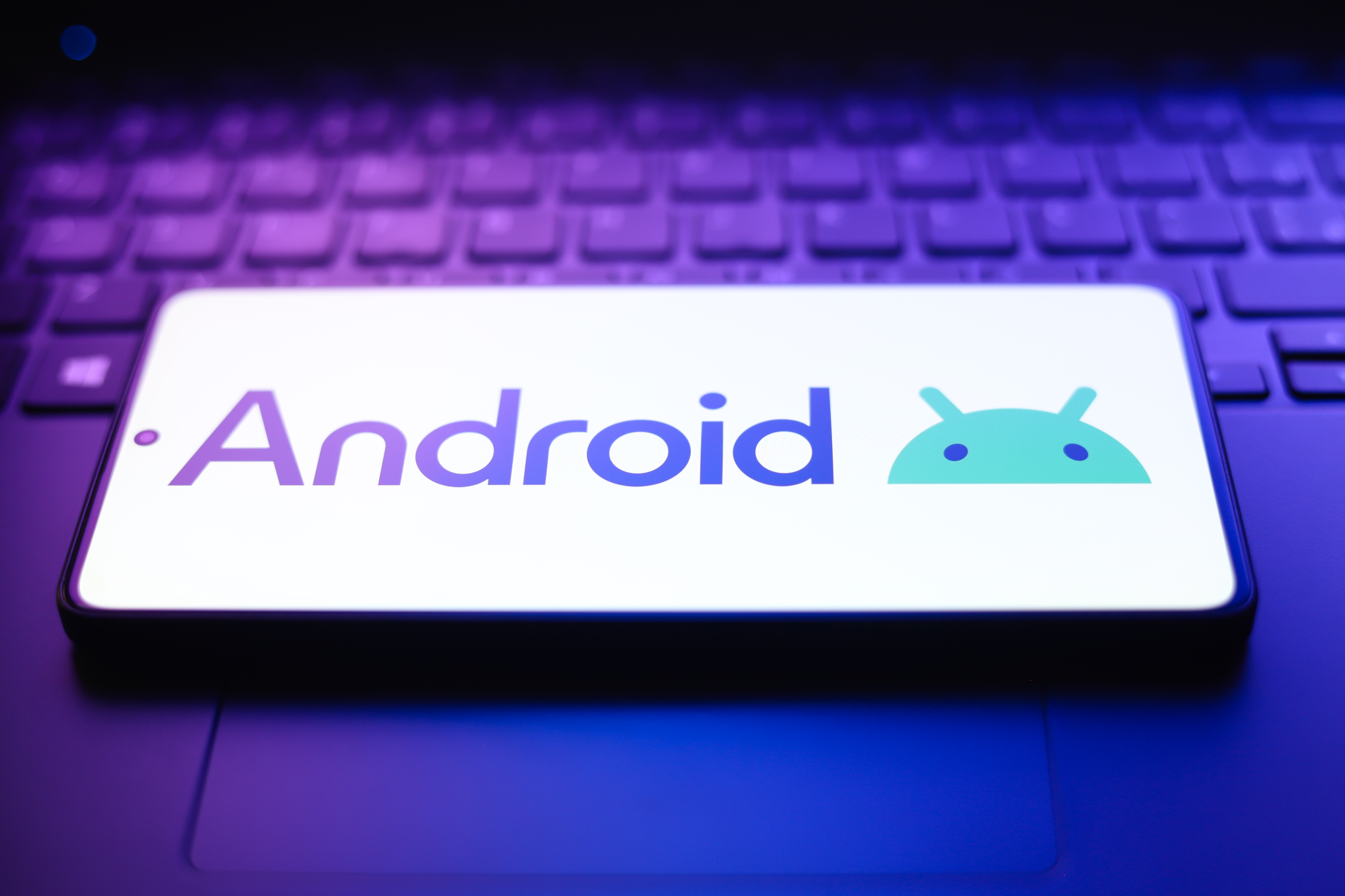 The Android logo appears on a smartphone screen in this photo illustration.
