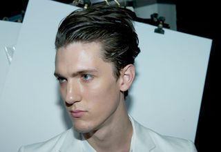 male model with slick back hair looking down to the left