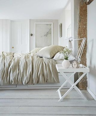 Luxury Scandinavian bedding on a bed against white walls, floors, and ceilings.