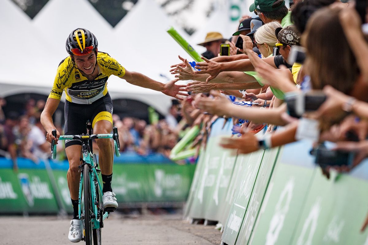 Sepp Kuss slaps hands with fans as he rides to victory in Snowbird Resort at the Tour of Utah
