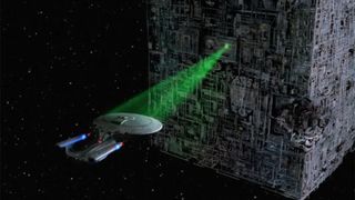A screenshot from Star Trek showing a spaceship using a tractor beam