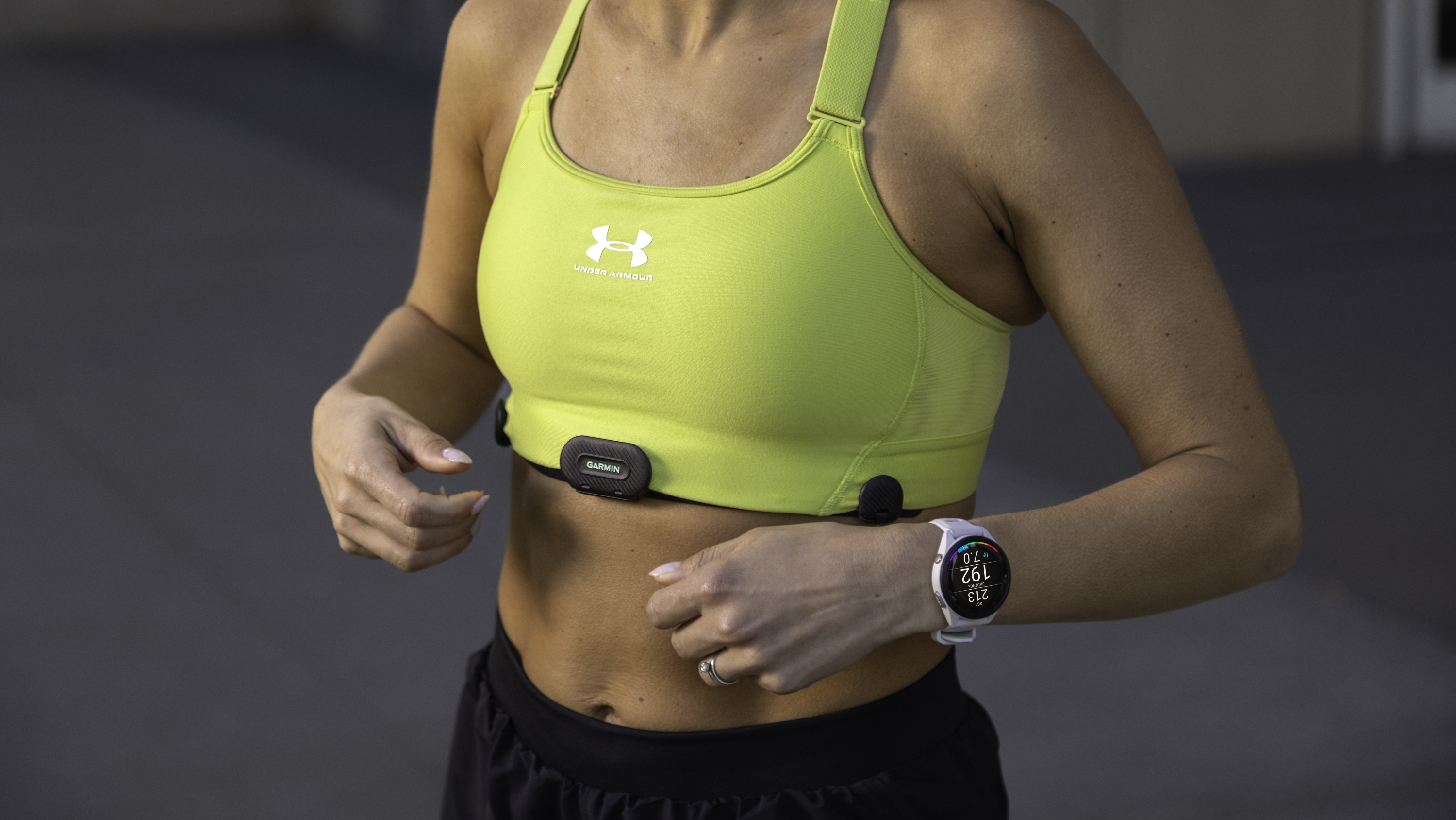 A woman wearing the Garmin HRM-Fit on her sports bra