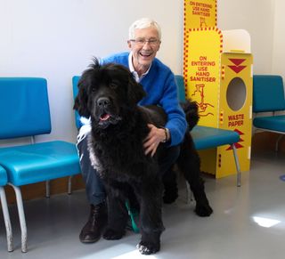Paul O'Grady poses with Peggy, a large black Newfoundland, at Battersea Dogs & Cats Home