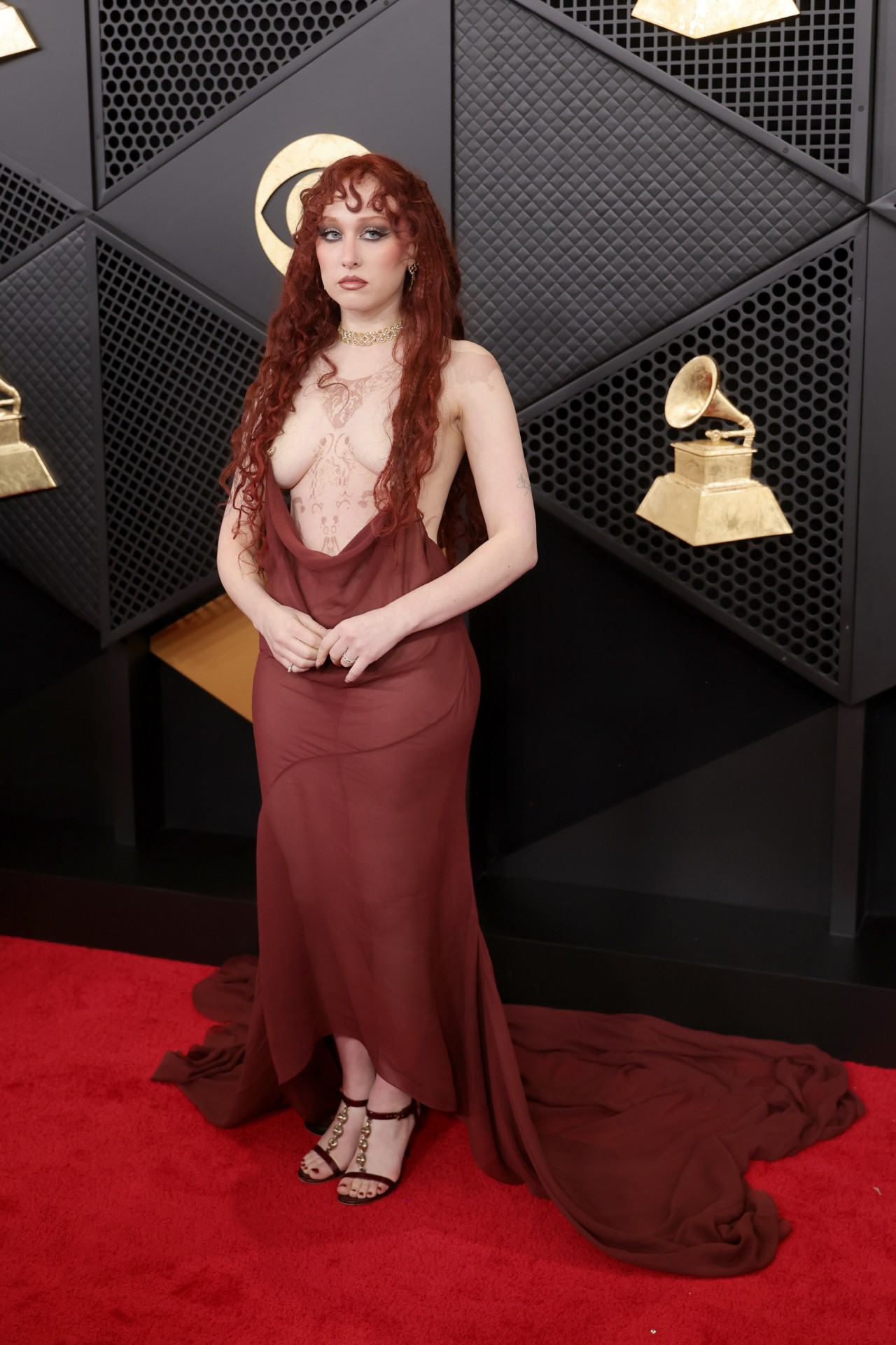 Chappell Roan attends the 68th GRAMMY Awards at Crypto.com Arena on February 01, 2026 in Los Angeles, California. She's wearing a sheer red top and her hair is covering her breasts.