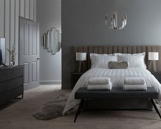 Gray bedroom with claw-like ceiling light fixture and two white lampshades