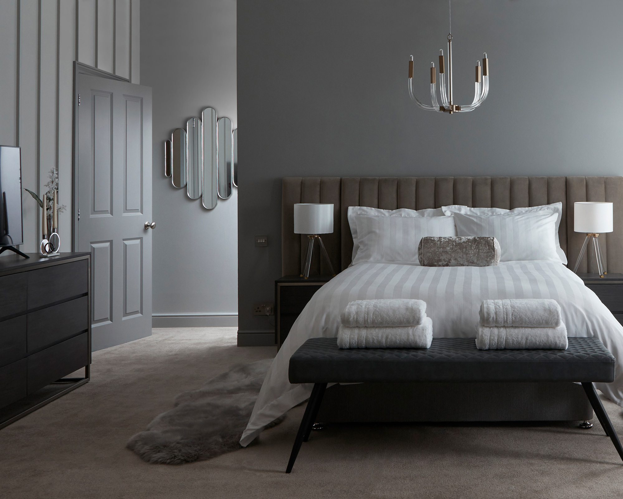 Grey bedroom with claw-like ceiling light fixture and two white lampshades