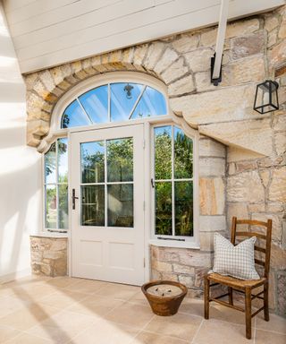 Conservatory with exposed stone walls in coastal cottage in Northumberland