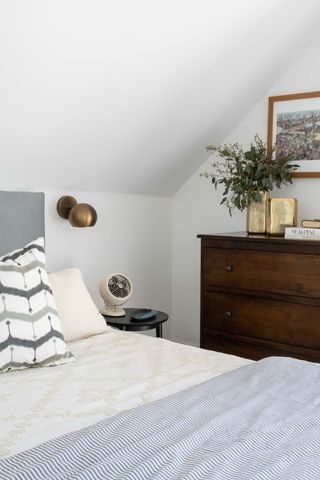 loft bedroom with grey bed and vintage wood chest of drawers