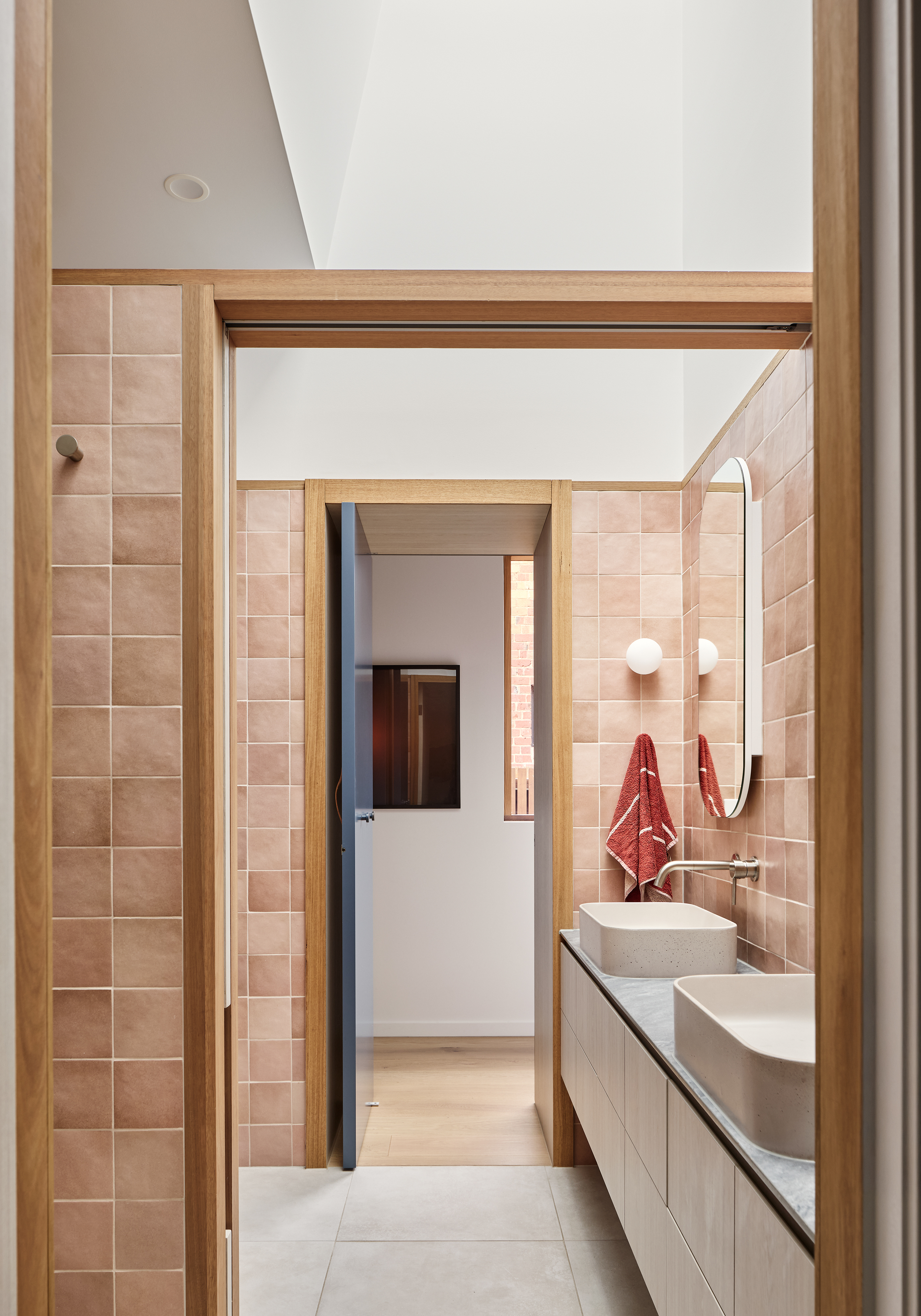A bathroom with red wall tiles and white porcelain tiles