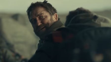 Gerard Butler as John Garrity looks over this shoulder as his family crosses a bridge in Greenland 2: Migration.