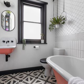 black and white tiled bathroom floor with pink sink and bathtub