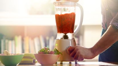 Blender with smoothie on a kitchen surface
