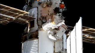 two spacesuited cosmonauts work outside a space station during a spacewalk