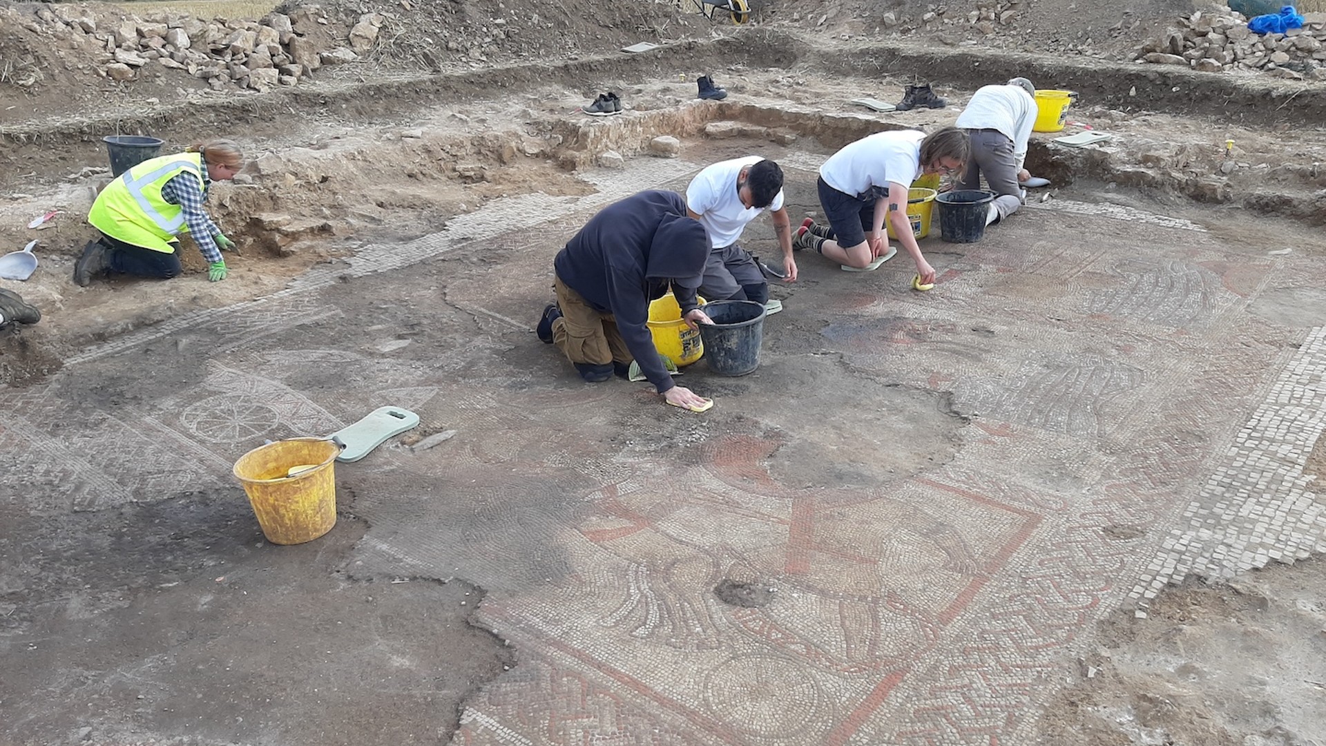 Archäologiestudenten und Mitarbeiter des Archäologischen Dienstes der University of Leicester der University of Leicester reinigen sorgfältig das vollständig freigelegte Mosaik aus dem Trojanischen Krieg.