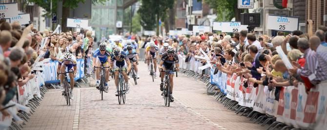 The four remaining breakaway riders sprint for the stage win with the peloton in hot pursuit