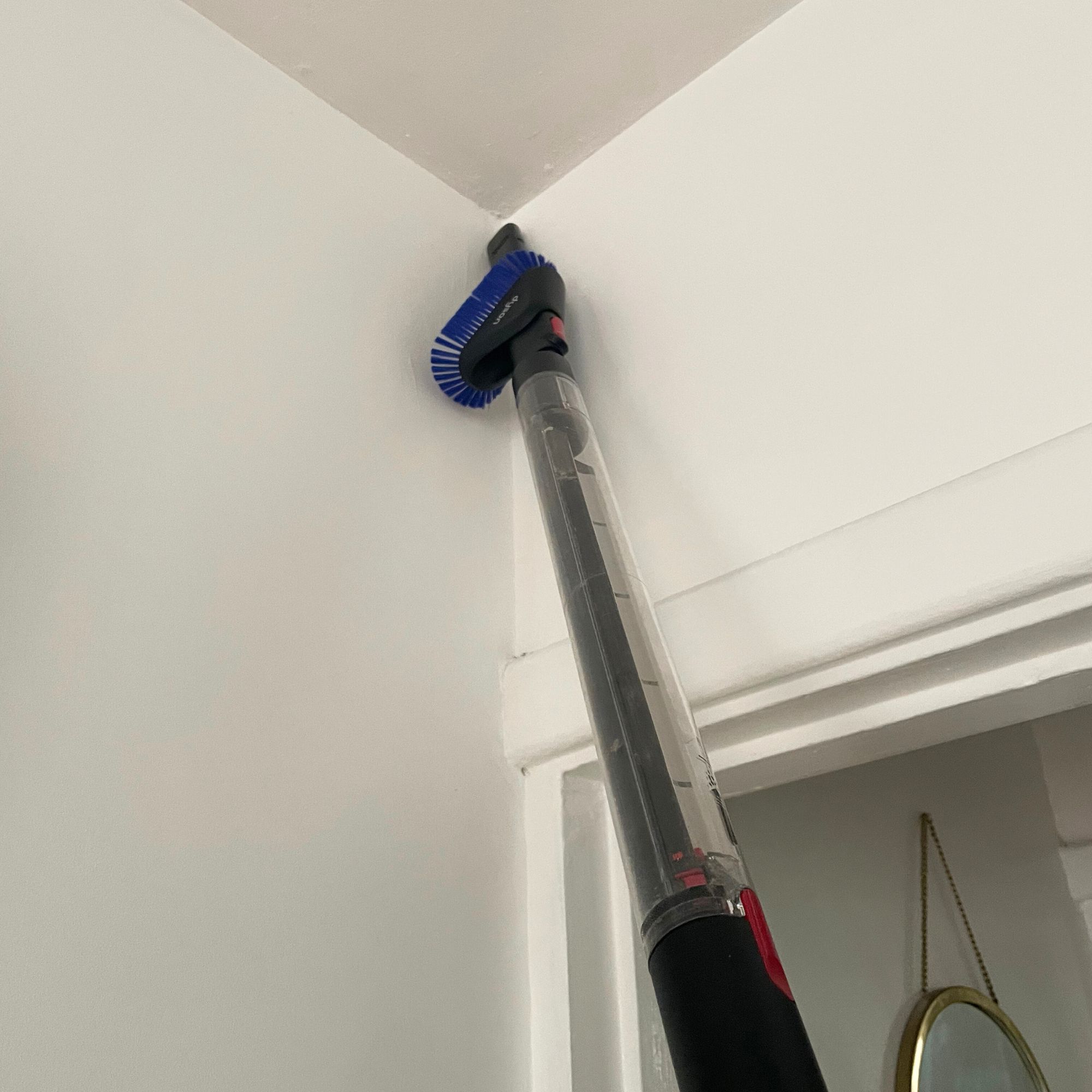 Using the crevice tool of the Dyson PencilVac to clean corners of the room