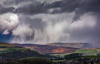 Hail and a rainbow can be seen across Derbyshire's High Peak In the Peak District National park.