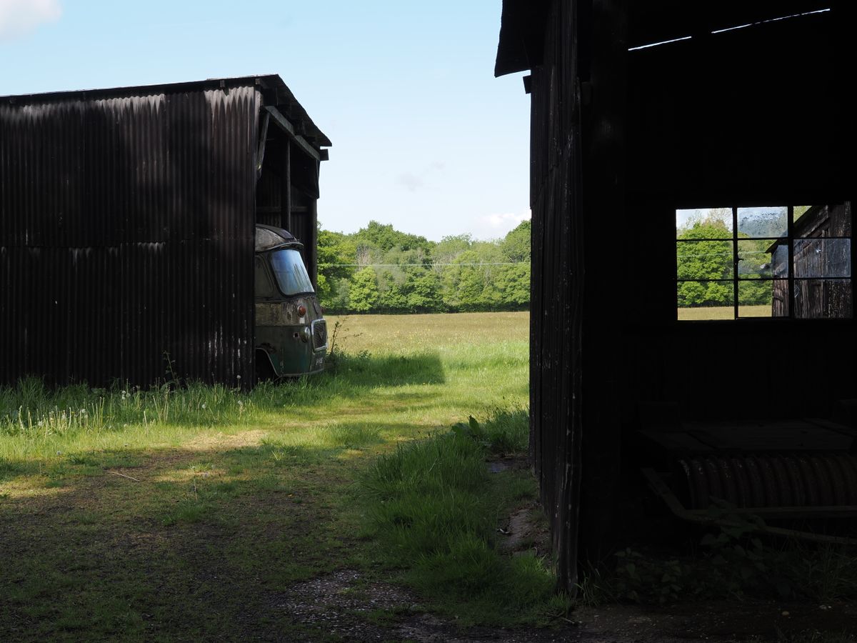 A outbuilding with an old vehicle poking out of the front
