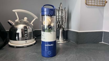 Nutribullet Magic Bullet portable blender making a banana, blueberry and kale smoothie