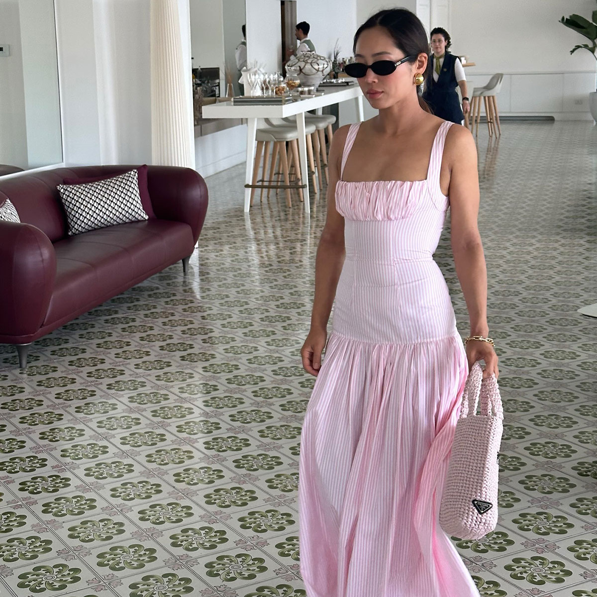@aimeesong in a pink Rowen Rose drop waist midi dress walking in Italy