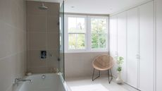 beige bathroom with shower and closed storage