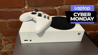 Microsoft Xbox Series S on a table with a controller on top of it and a Cyber Monday banner in the upper-right corner
