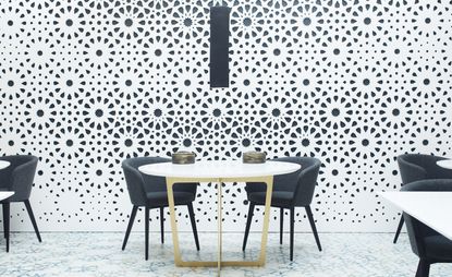 Tables & chairs in front of monochrome painted wall