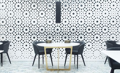 Tables &amp; chairs in front of monochrome painted wall