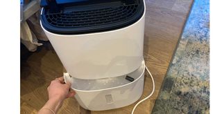 MeacoDry Arete One 10L dehumidifier review with our tester showing where the water tank is located