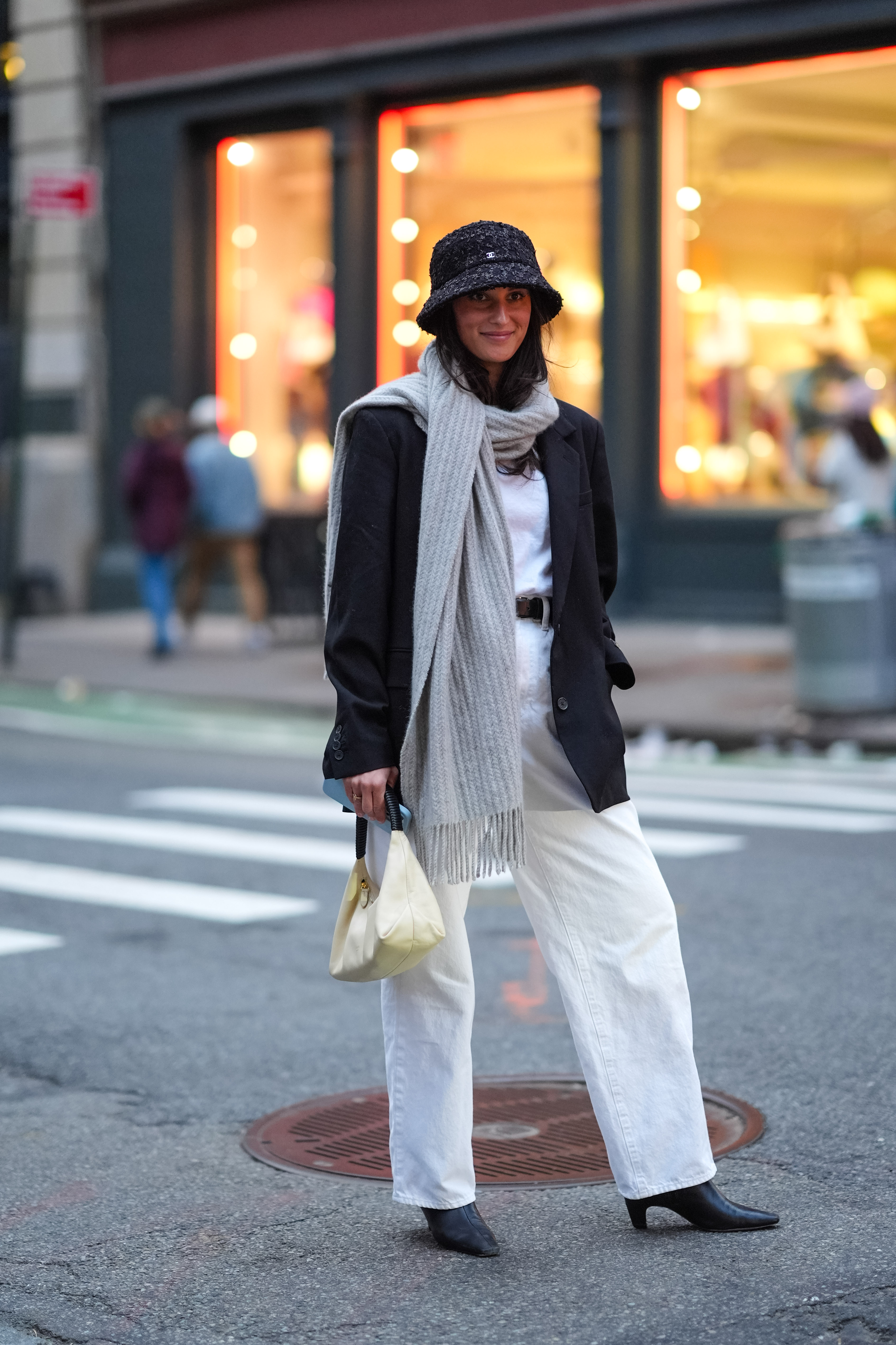 a woman wearing a blazer, t-shirt, and white trousers in street style