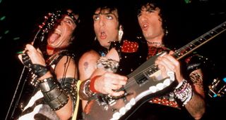 Kiss sans make-up in 1985. With Gene Simmons [left] sticking his tongue out, Paul Stanley looking spaced, and Bruce Kulick taking a solo on a silver Superstrat.