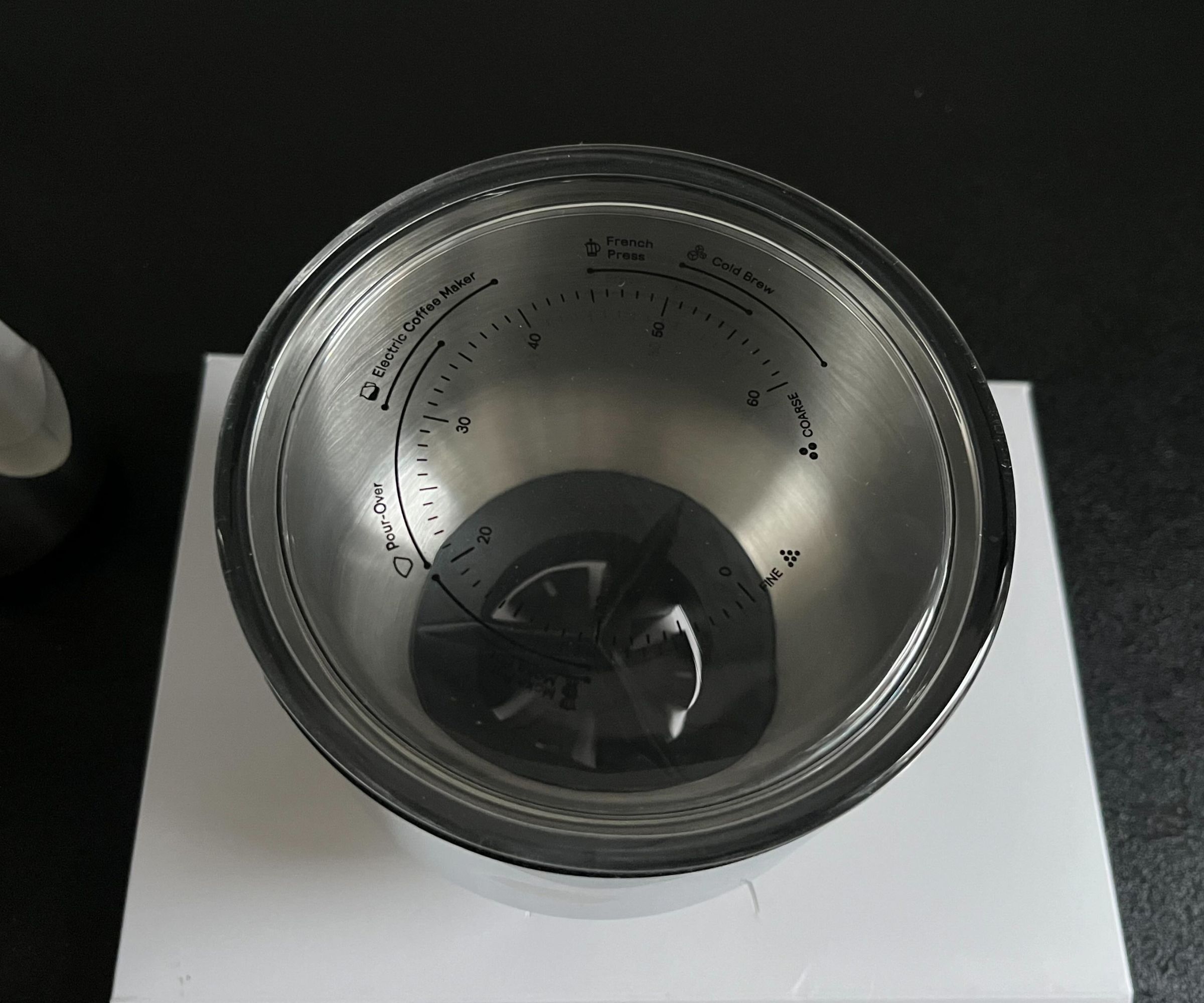 A close up of the glass lid of the Aarke coffee grinder, etched with the grind settings suitable for each type of coffee brewing method