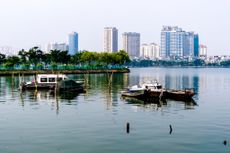 The skyline of Hanoi's city centre is reflected on the surface of the West Lake, Ho Tay