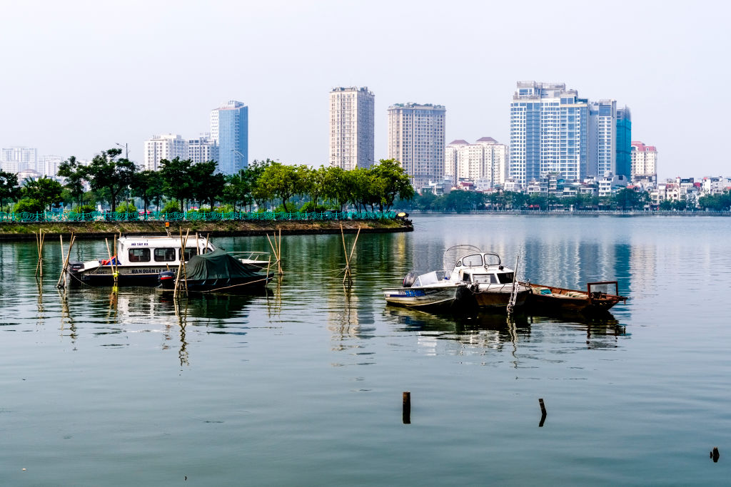 The skyline of Hanoi's city centre is reflected on the surface of the West Lake, Ho Tay