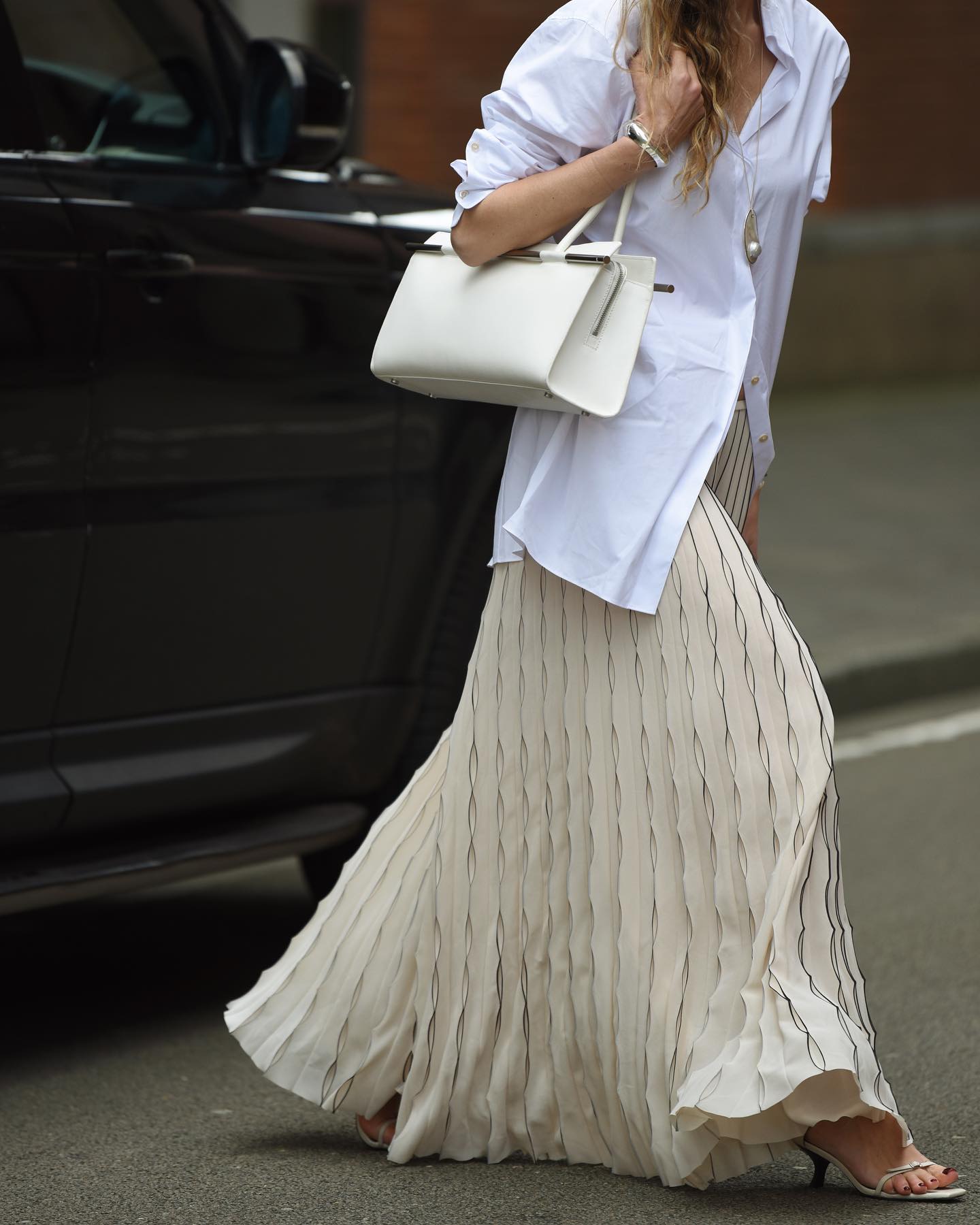 A woman wearing a white shirt and a skirt