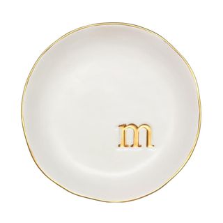 A gold and white trinket tray with an 'm' on it