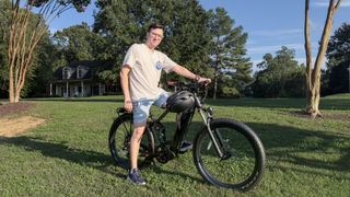 Paul Antill sat on the Mod Bikes Black 3 electric bike in a park