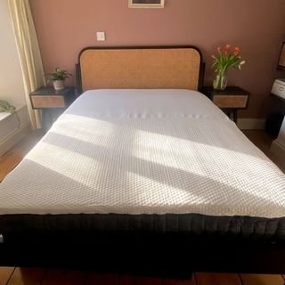 The Emma Hybrid Original mattress being tested in a bedroom with a wooden floor