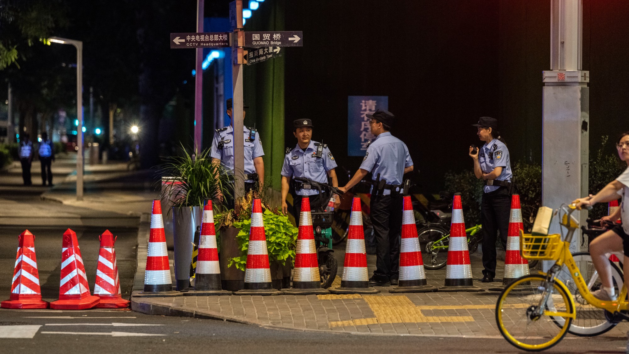 Beijing police stand behind traffic cones at a security roadblock
