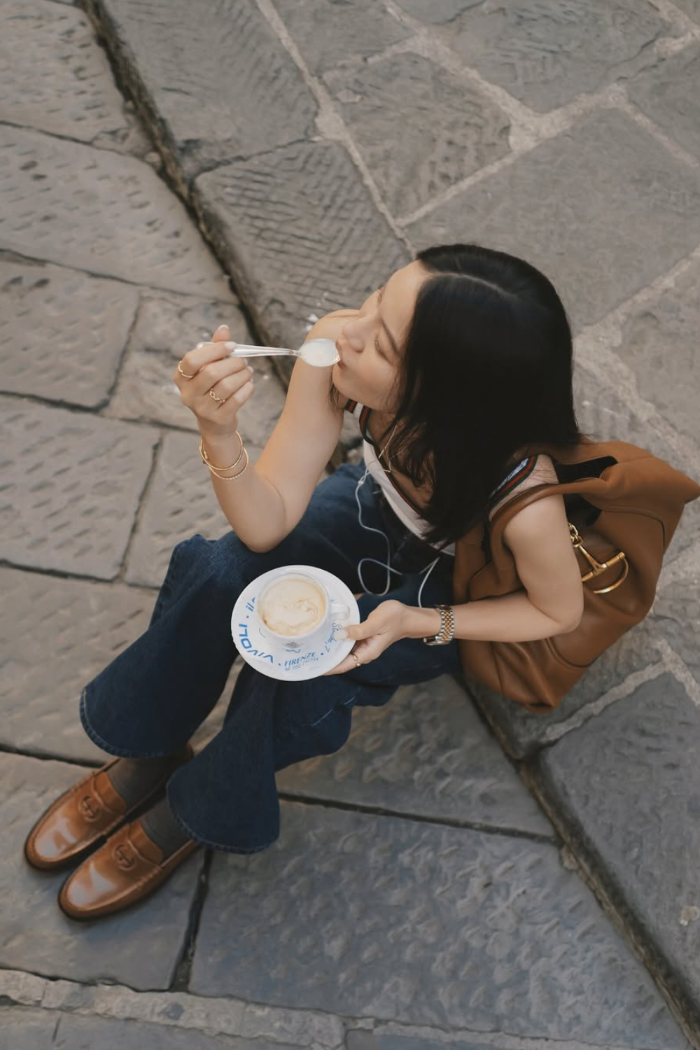 @tsangtastic wears brown leather Gucci loafers, jeans and white tank top